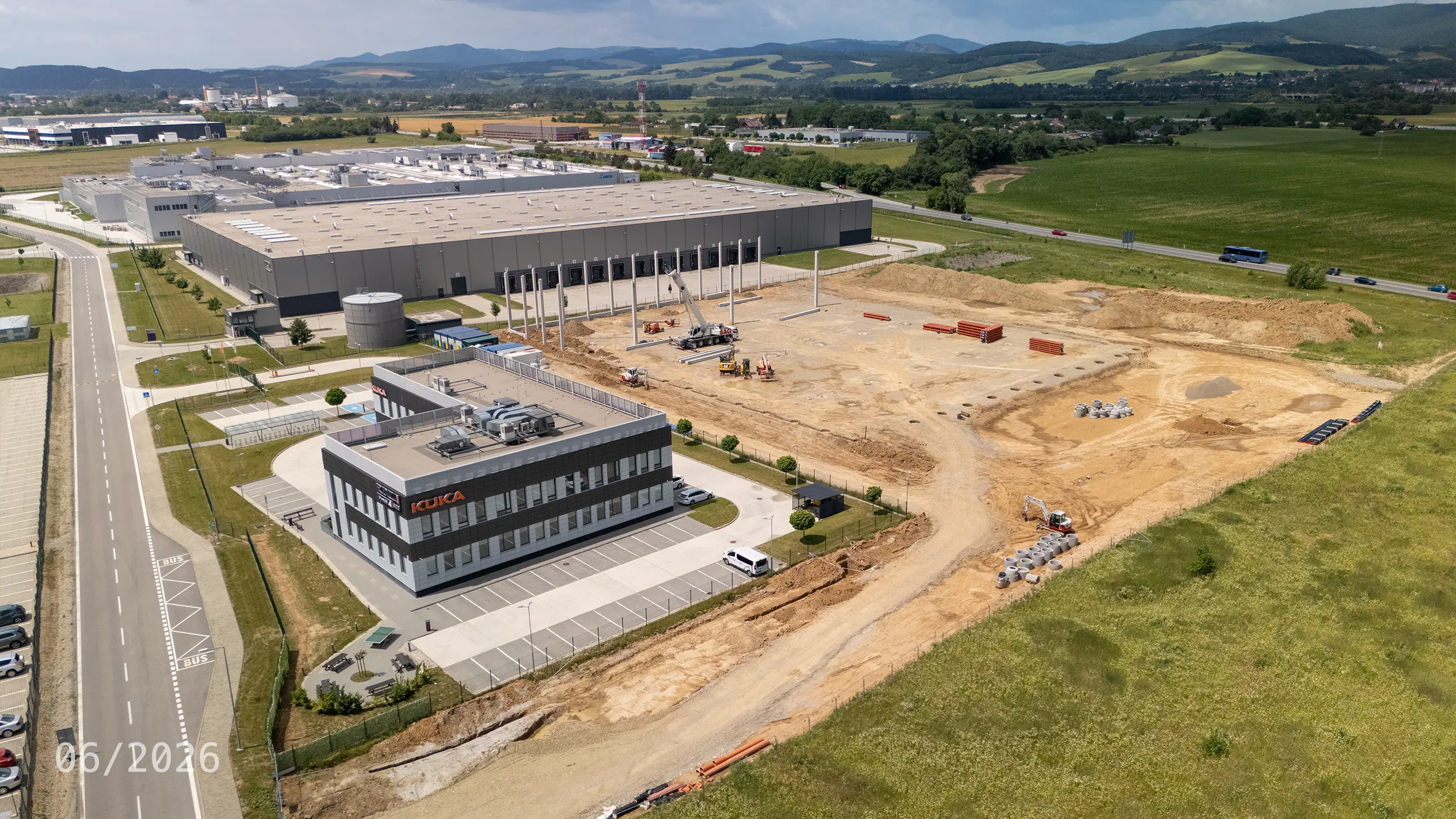 Priemyselný projekt Dubnica 4 – výstavba nosnej konštrukcie novej skladovej a administratívnej haly v Dubnici nad Váhom. Na fotografii sú viditeľné realizované základy a montáž železobetónových stĺpov, ktoré tvoria základ budúceho logistického objektu nadväzujúceho na existujúce budovy priemyselného parku.