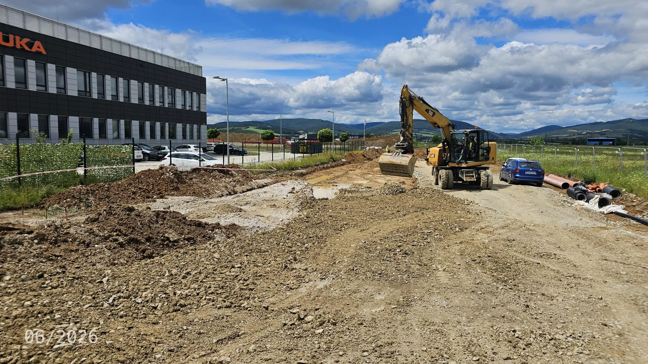 Priemyselný projekt Dubnica 4 – výstavba nosnej konštrukcie novej skladovej a administratívnej haly v Dubnici nad Váhom. Na fotografii sú viditeľné realizované základy a montáž železobetónových stĺpov, ktoré tvoria základ budúceho logistického objektu nadväzujúceho na existujúce budovy priemyselného parku. - obrázok 8