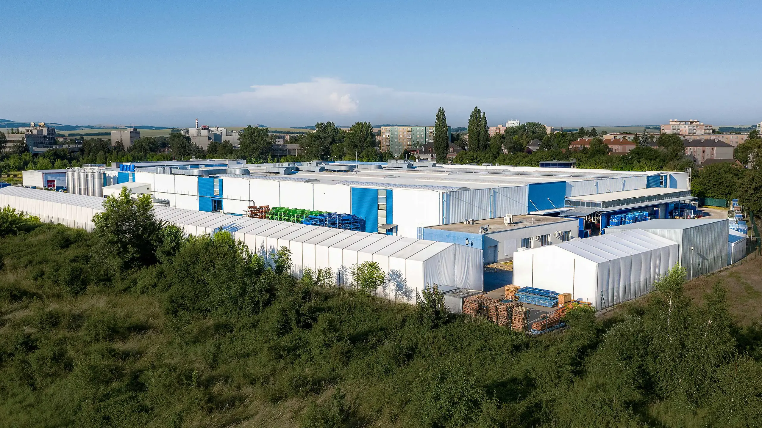 Industrial Project Senica 1 – Aerial view of a manufacturing and warehouse complex leased to an international automotive company, complemented by a newly developed research and development center. The modern industrial facilities are located in a strategic area with excellent access to the D2 motorway and provide extensive production, storage, and office space. - obrázok 4