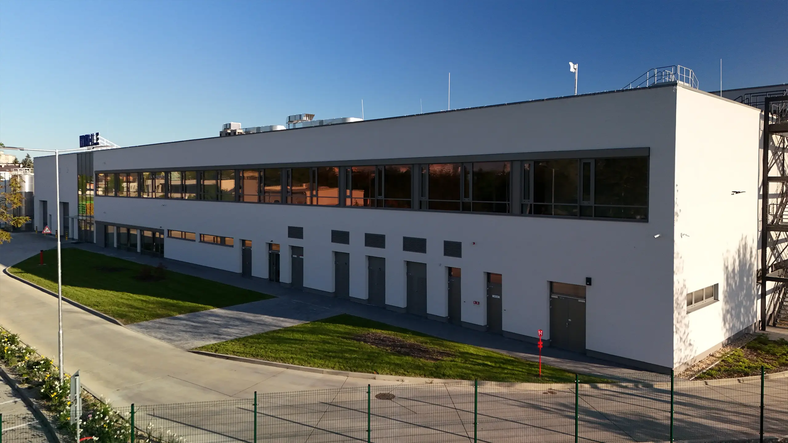 Industrial project Senica 3 – modern manufacturing and warehouse facility for an international automotive company in Senica with expanded production capacity, loading docks and logistics infrastructure. The aerial view captures the extensive MAHLE industrial complex in a strategic location with excellent access to the D2 motorway and strong long-term development potential. - obrázok 3