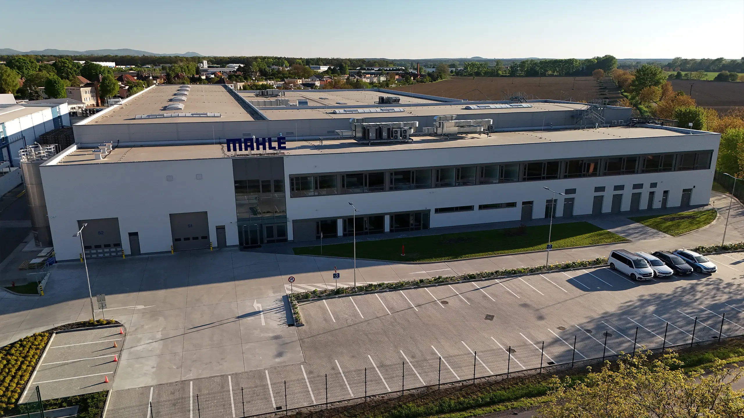 Industrial project Senica 3 – modern manufacturing and warehouse facility for an international automotive company in Senica with expanded production capacity, loading docks and logistics infrastructure. The aerial view captures the extensive MAHLE industrial complex in a strategic location with excellent access to the D2 motorway and strong long-term development potential. - obrázok 4