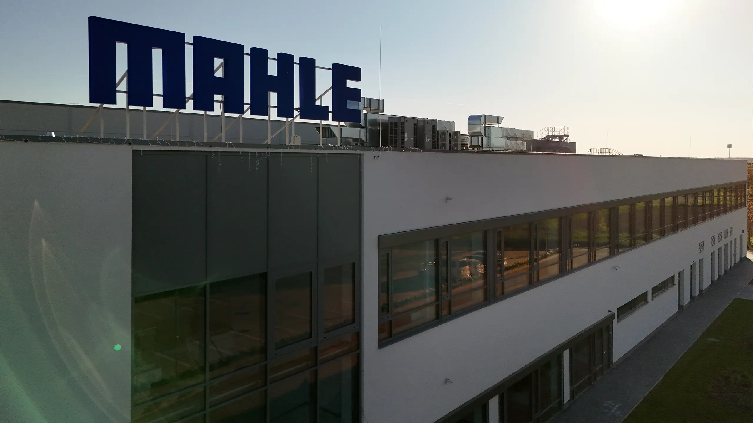 Industrial project Senica 3 – administrative and technological section of the modern MAHLE manufacturing and warehouse complex. The building detail highlights contemporary industrial architecture, office facilities and technical infrastructure supporting expanded production and logistics capacities for the automotive industry in the strategic Senica location. - obrázok 5