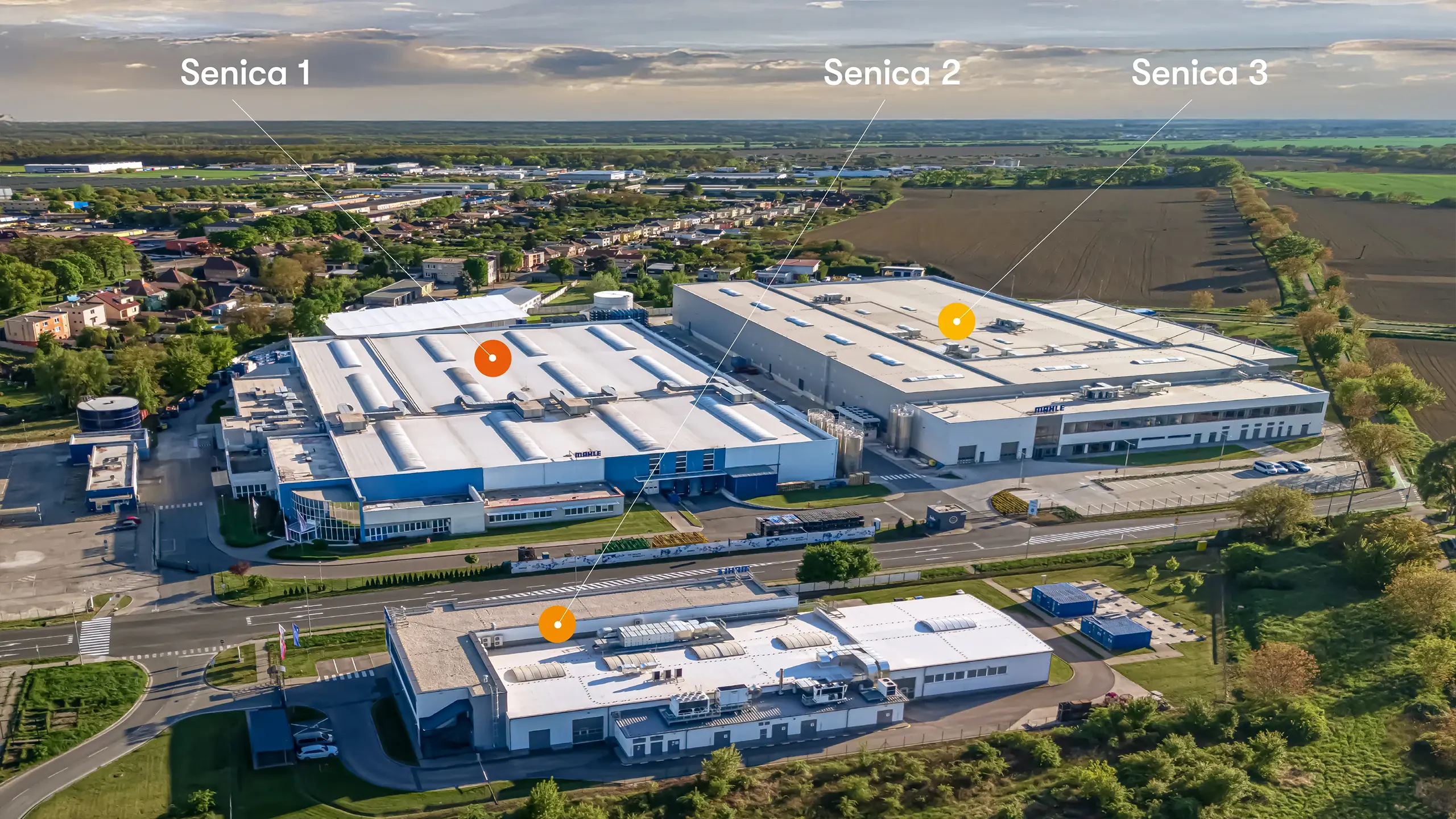 Industrial project Senica 3 – aerial view of the industrial and logistics complex in Senica showing the individual development phases Senica 1, Senica 2 and Senica 3. The new Senica 3 extension expands the existing MAHLE manufacturing and warehouse capacities and supports the continued growth of automotive production in a strategic location with excellent access to the D2 motorway. - obrázok 6
