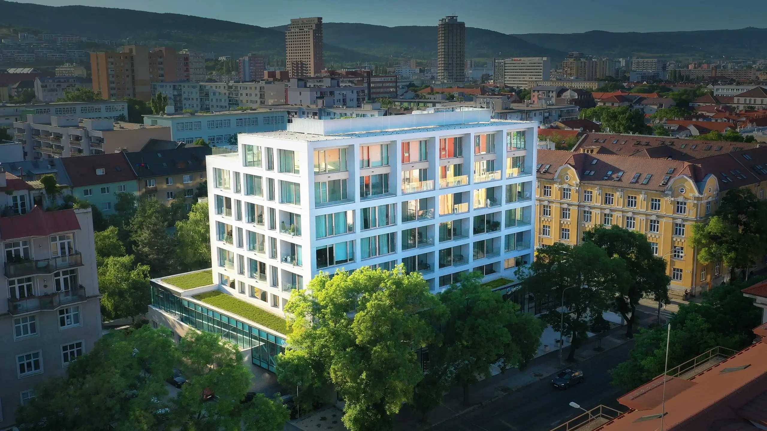 Rezidenčný projekt Vajnorská 21 – moderný polyfunkčný objekt v Bratislave – Novom Meste vzniknutý prestavbou pôvodnej administratívnej budovy. Letecký pohľad zachytáva nadčasovú architektúru rezidenčného projektu s bytmi, mezonetmi, obchodnými a kancelárskymi priestormi v atraktívnej mestskej lokalite s výbornou dostupnosťou a kompletnou občianskou vybavenosťou.