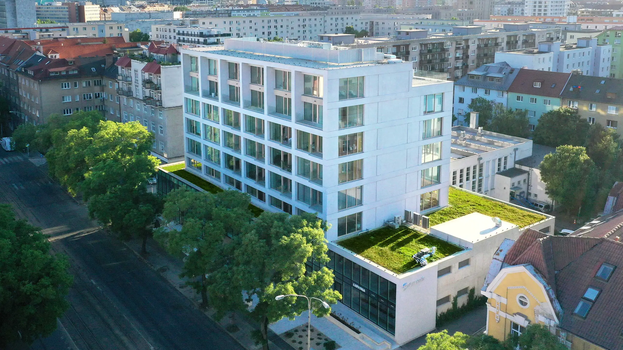 Rezidenčný projekt Vajnorská 21 – moderný polyfunkčný objekt v Bratislave – Novom Meste vzniknutý prestavbou pôvodnej administratívnej budovy. Letecký pohľad zachytáva nadčasovú architektúru rezidenčného projektu s bytmi, mezonetmi, obchodnými a kancelárskymi priestormi v atraktívnej mestskej lokalite s výbornou dostupnosťou a kompletnou občianskou vybavenosťou. - obrázok 2