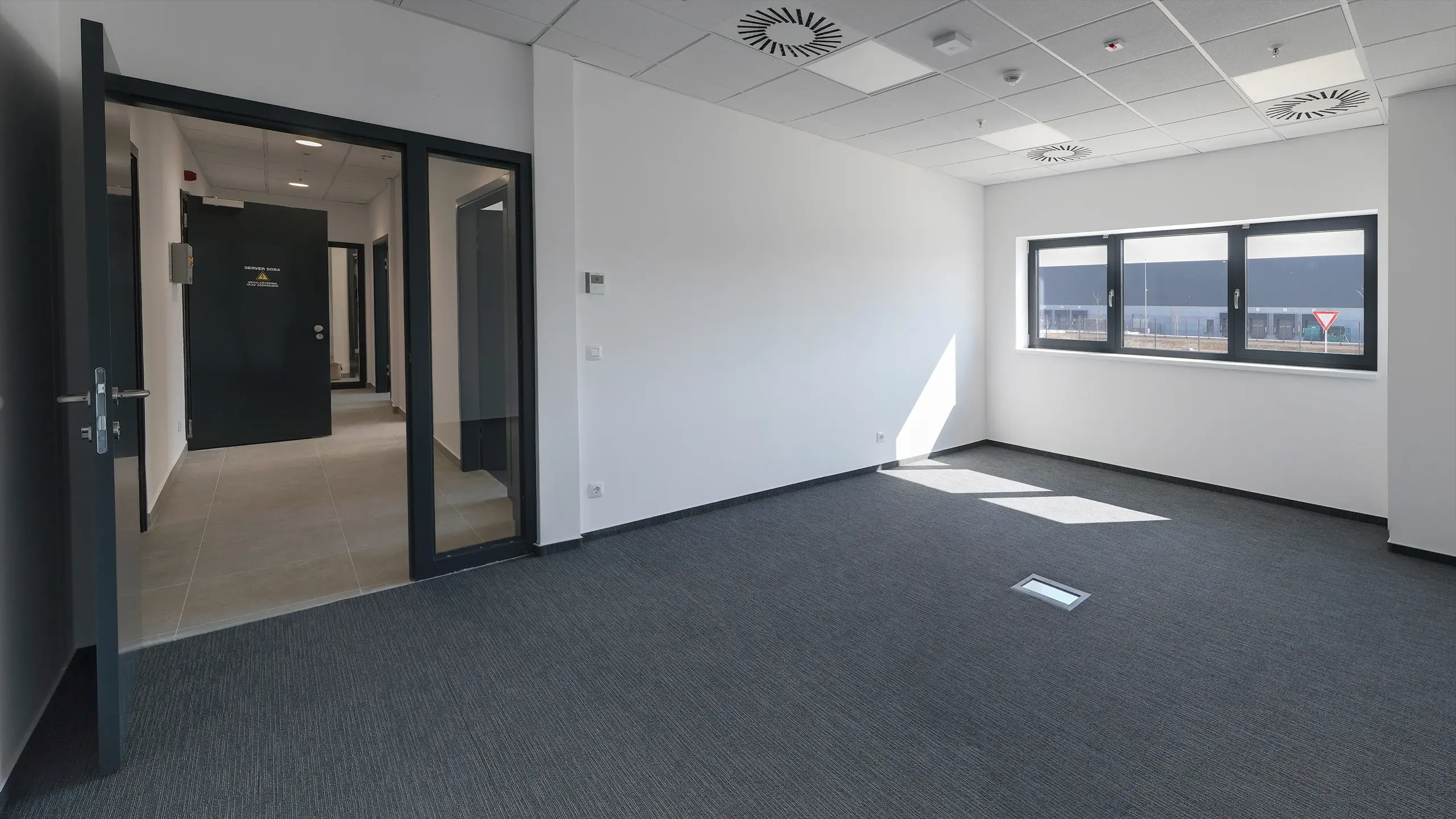 Priemyselný projekt Záhreb 1 – moderné administratívne priestory v logistickom parku pri Záhrebe. Fotografia zachytáva priestrannú kanceláriu s veľkými oknami, prirodzeným denným osvetlením a kvalitným technickým vybavením, navrhnutú pre efektívnu prevádzku logistických, výrobných a distribučných spoločností. - obrázok 4