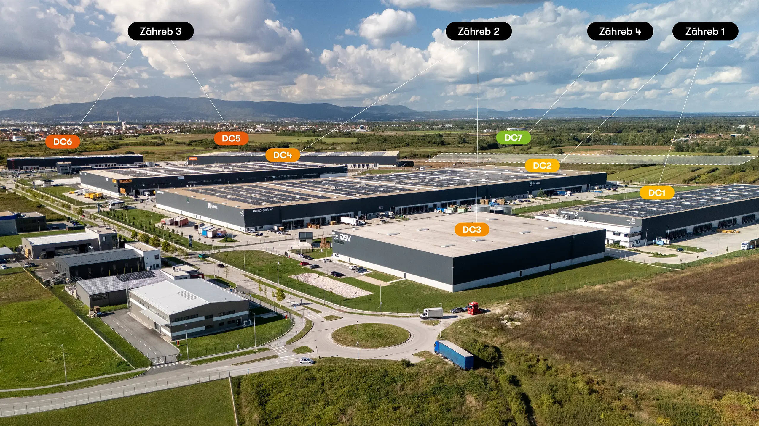 Industrial Project Zagreb 4 – panoramic aerial view of the fourth expansion phase of the Zagreb logistics park within the context of the entire industrial development. The photograph shows existing facilities from previous phases, land designated for further expansion, and the park’s strategic location with excellent transport connections. Upon completion, the entire industrial park will provide more than 210,000 m² of premium leasable space featuring photovoltaic systems and BREEAM certification. - obrázok 1