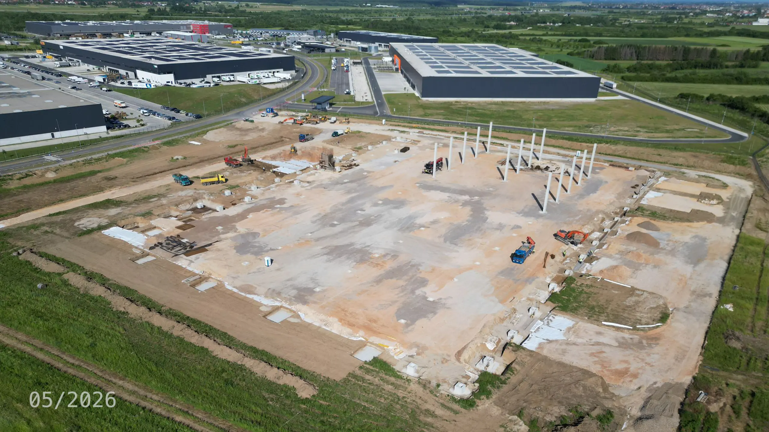Industrial Project Zagreb 4 – aerial view of the construction of the fourth phase of the Zagreb logistics park. The photograph shows foundation works, the installation of structural columns and ongoing construction activities for a new logistics facility. The project expands the existing industrial park with additional premium-grade space equipped with modern technologies, photovoltaic systems and designed to meet BREEAM certification standards. - obrázok 11