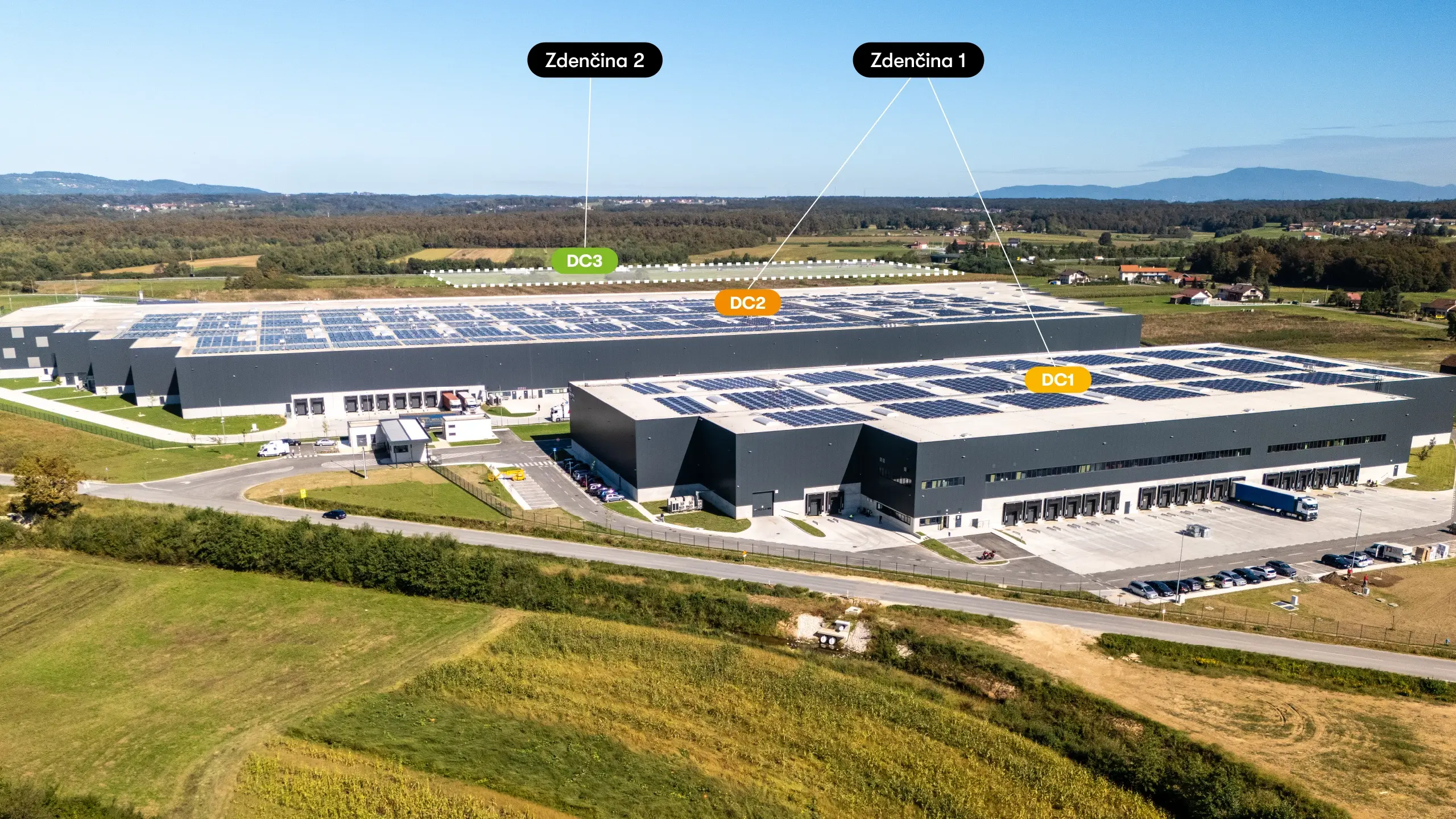 Industrial project Zdenčina 2 – aerial view of the Zdenčina logistics park showing the existing DC1 and DC2 facilities and the designated location of the future DC3 building within the Zdenčina 2 development. The project builds on the success of Zdenčina 1 and is designed to support further expansion of logistics capacity for existing and future tenants. Its strategic location near the A1 motorway, together with planned photovoltaic systems, electric mobility infrastructure and BREEAM certification, ensures a high standard of sustainable industrial development. - obrázok 3